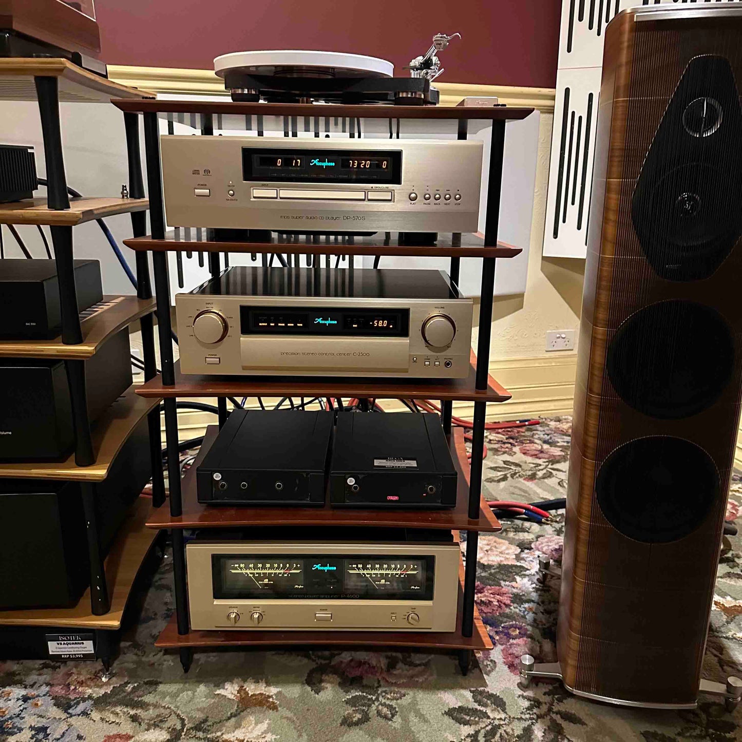 Audio equipment including amplifiers and speakers on a wooden shelf.