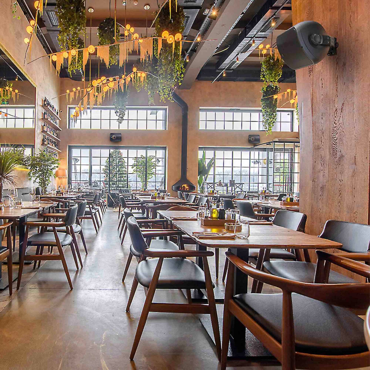 Modern restaurant interior with wooden tables, chairs, and large windows.