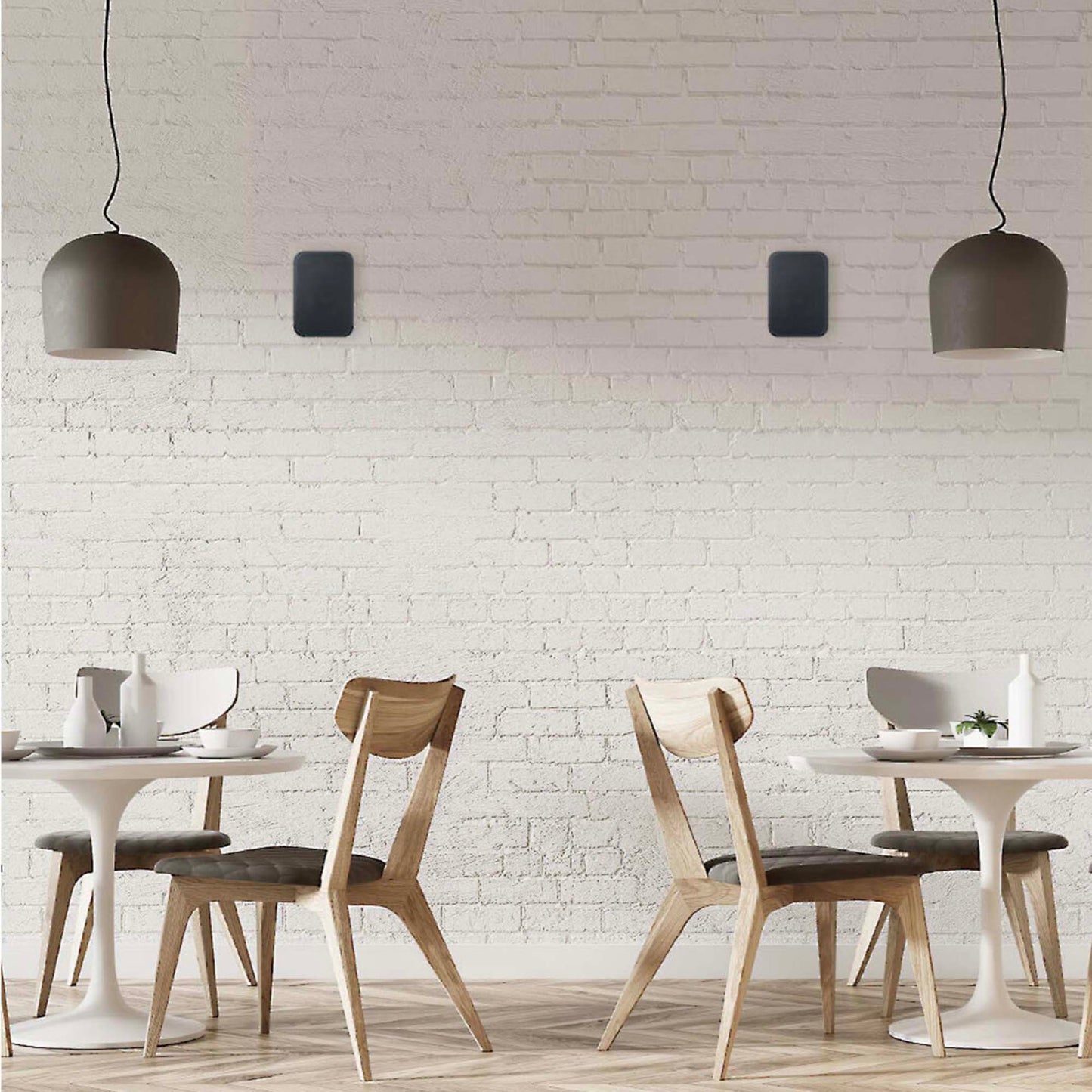 Dining area with wooden chairs and white tables against a white brick wall.