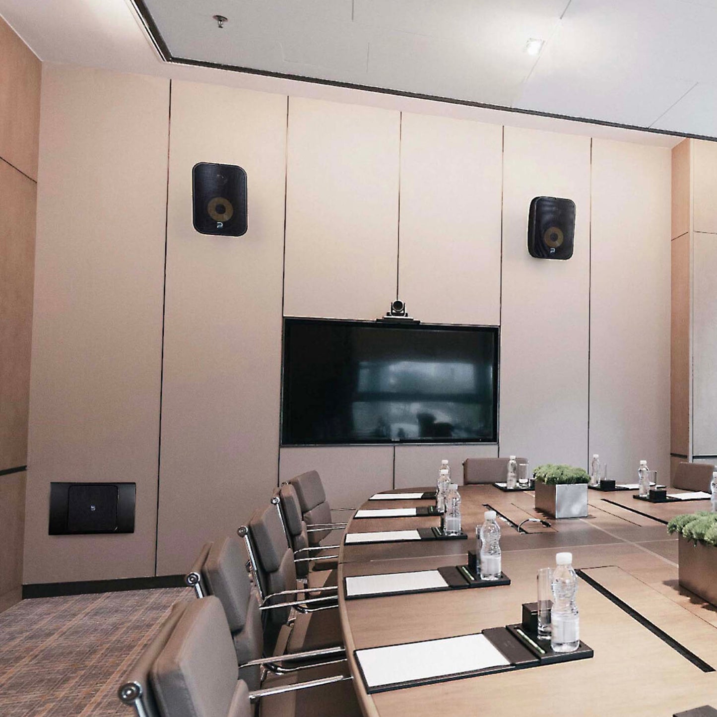 Modern conference room with a large screen, chairs, and decorative elements.