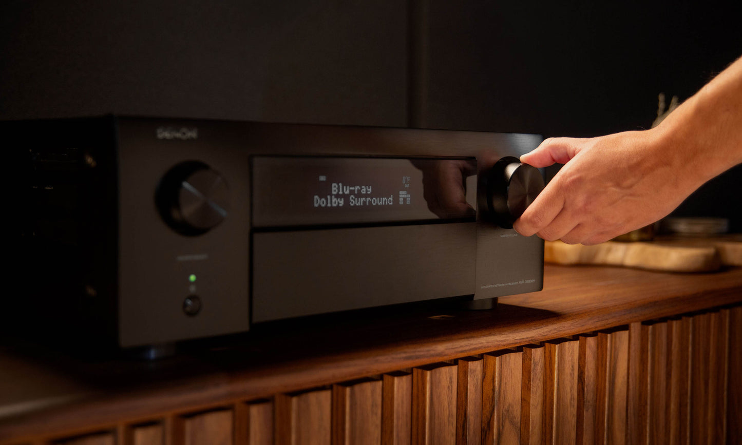 Hand changing volume of Denon AVC-X6800H 8K Home Theatre Amplifier