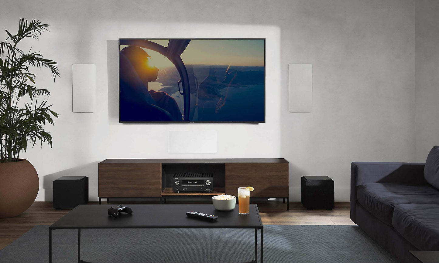 Denon AVC-X3800H on tv unit with television on wall and furniture