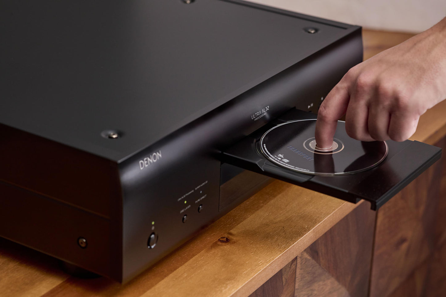 Someone placing a cd in the Denon DCD-3000NE