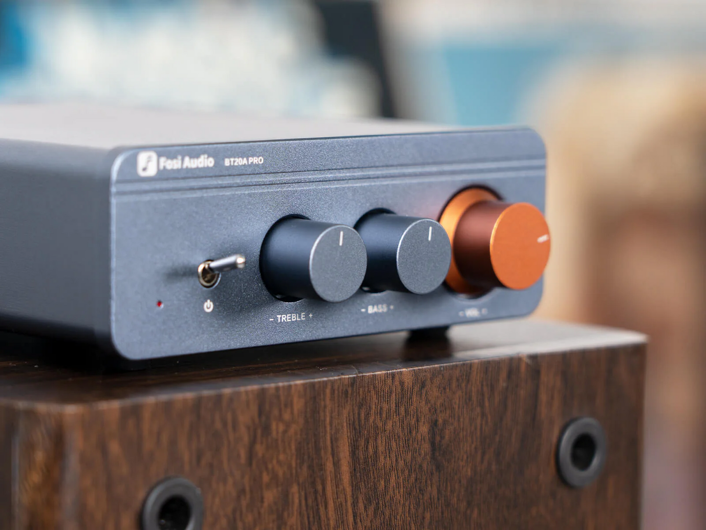 Fosi Audio BT20A Pro Bluetooth Integrated Amplifier sitting on top of a wooden speaker