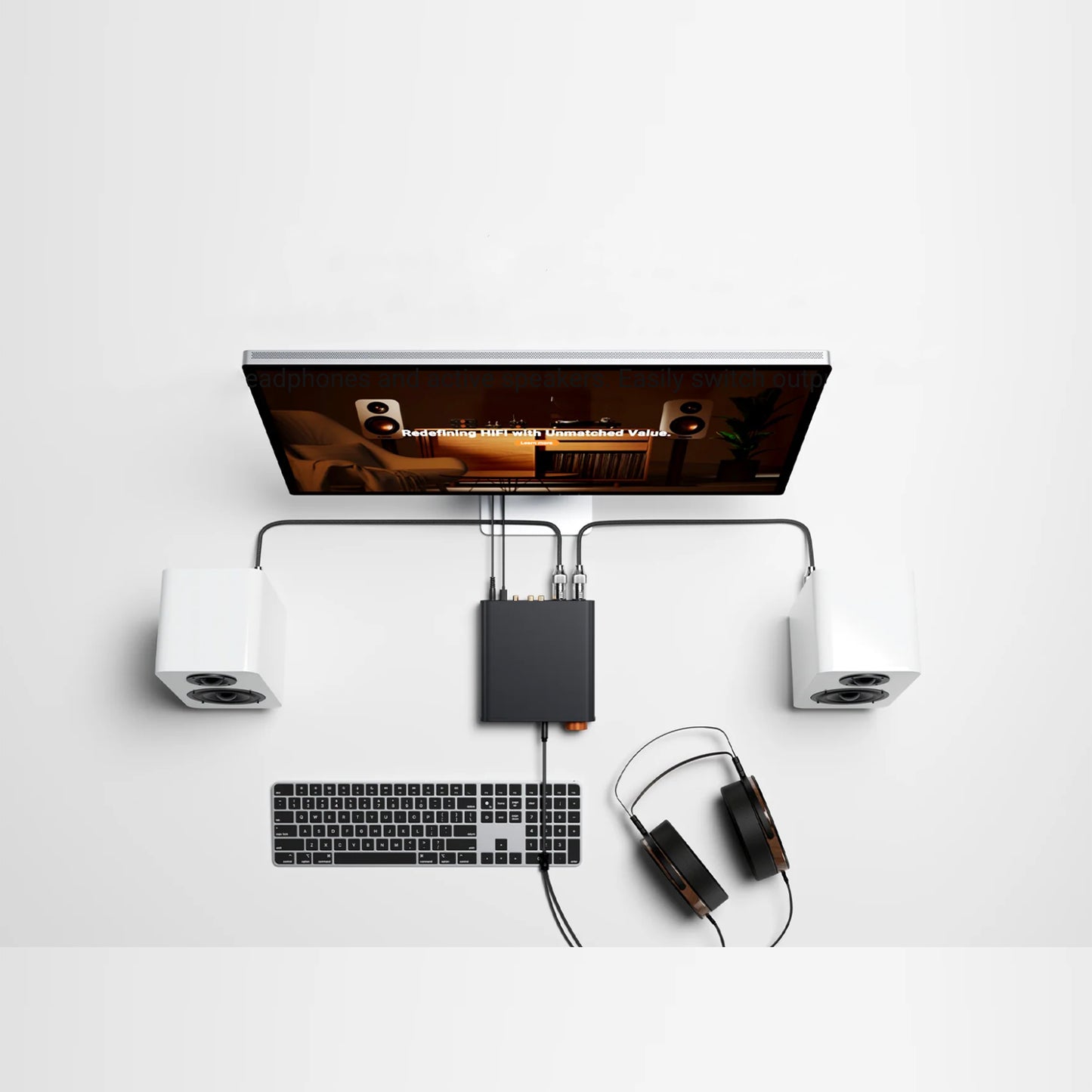 Computer setup with monitor, keyboard, speakers, and headphones on a white background