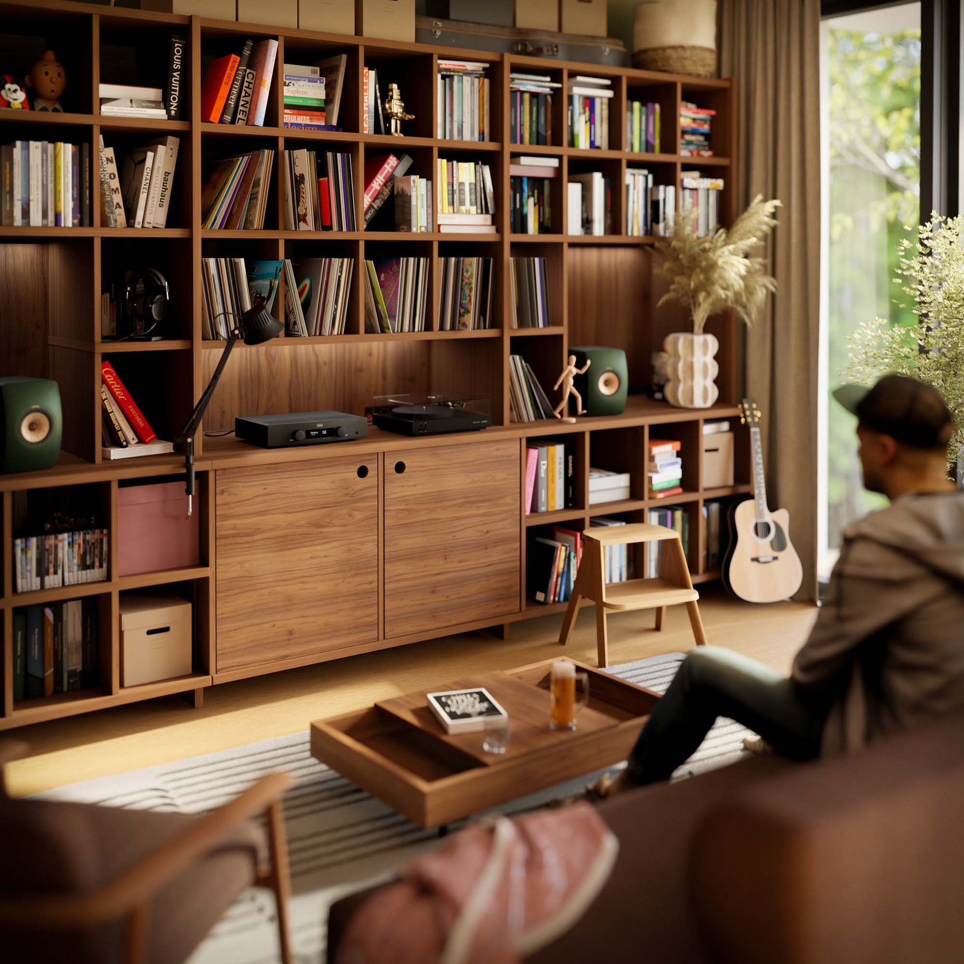 Living room with wooden bookshelf, coffee table, and person sitting on a couch.