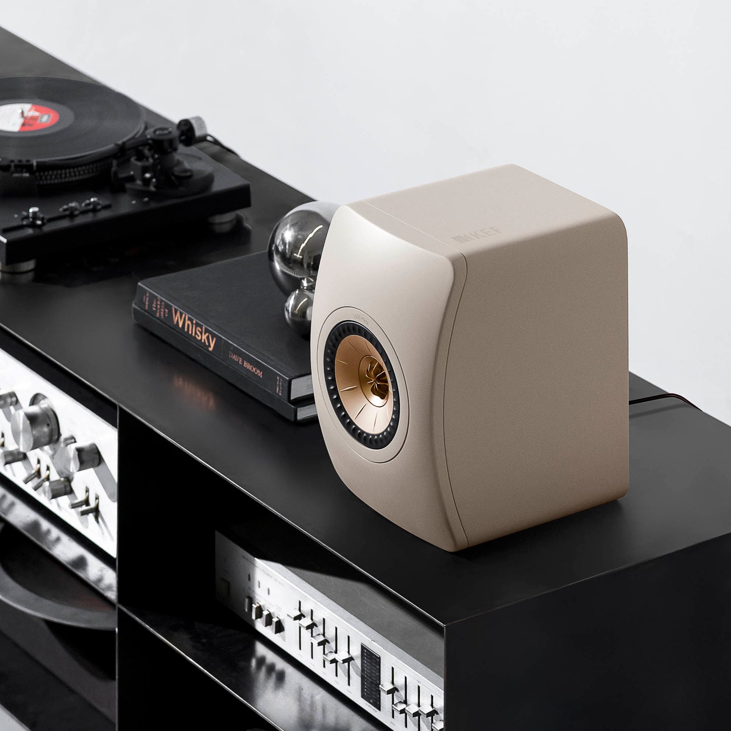 KEF LS50 Meta Bookshelf Speakers in Sand Shell finish on cabinet with turntable