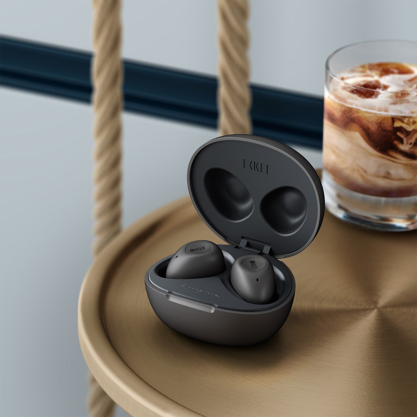 KEF Mu3 In-Ear Noise Cancelling Headphones on table with milky drink