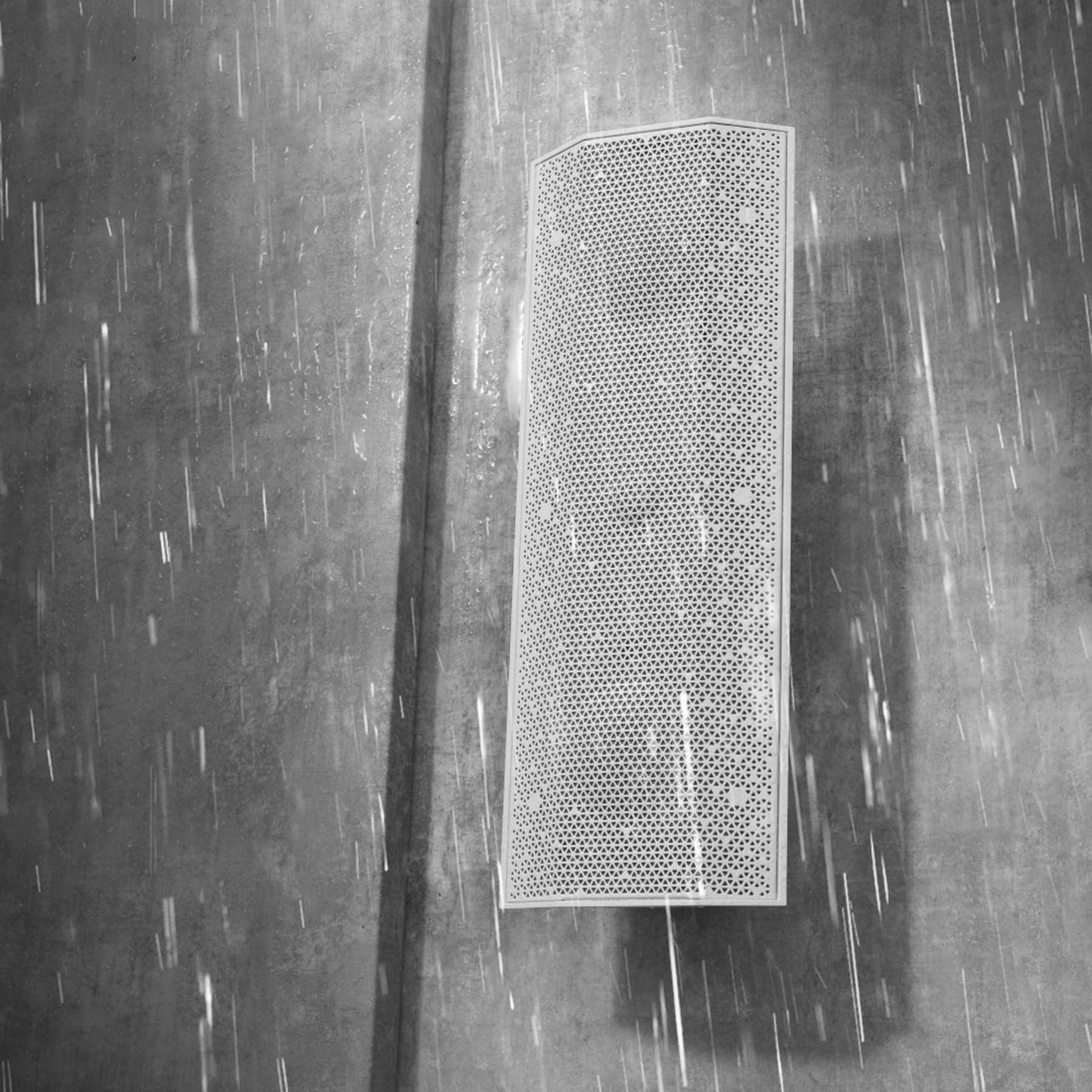 Lithe Audio IO1 Indoor Outdoor Passive Speaker on grey wall in the rain