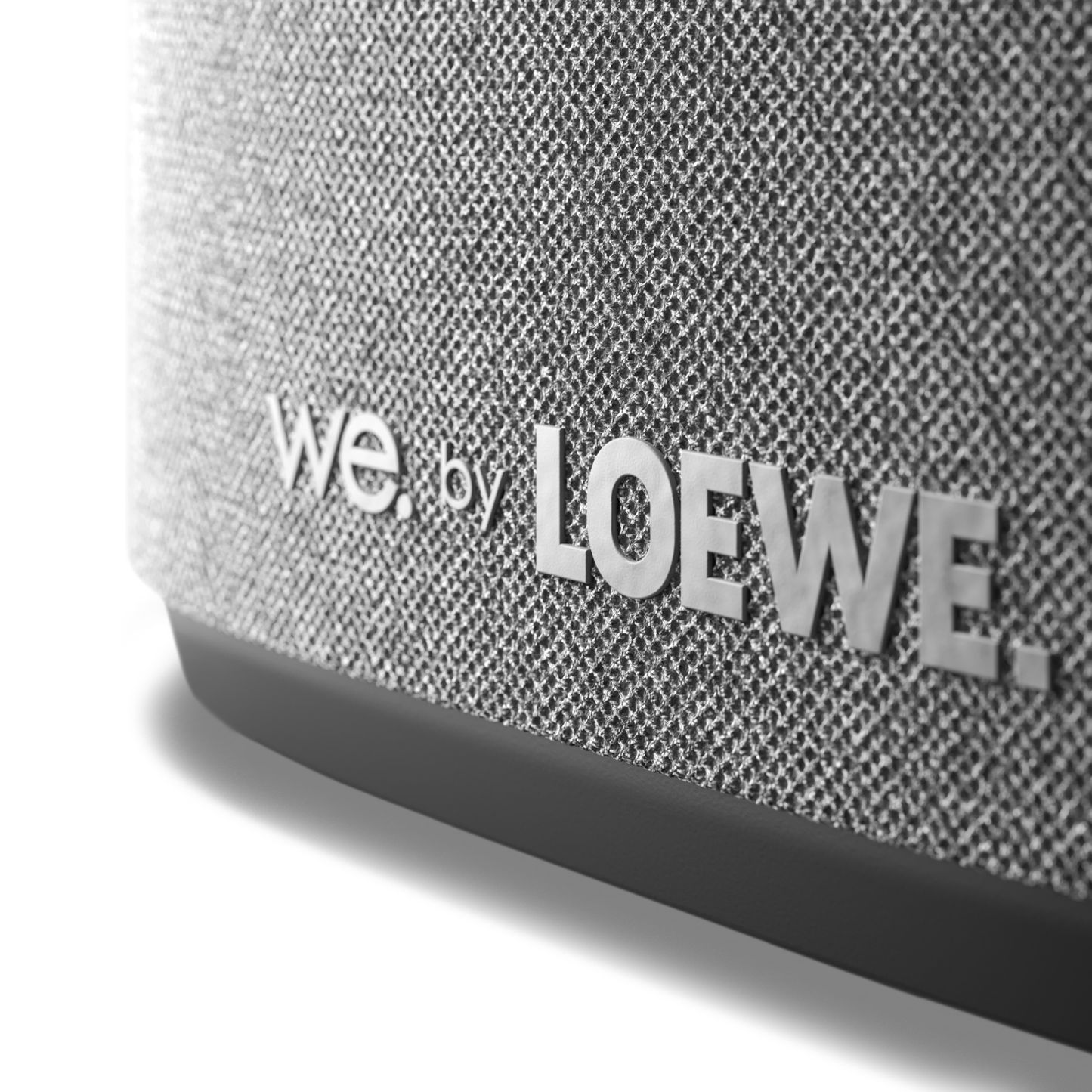 Close-up of a textured speaker with 'we by LOEWE' branding.