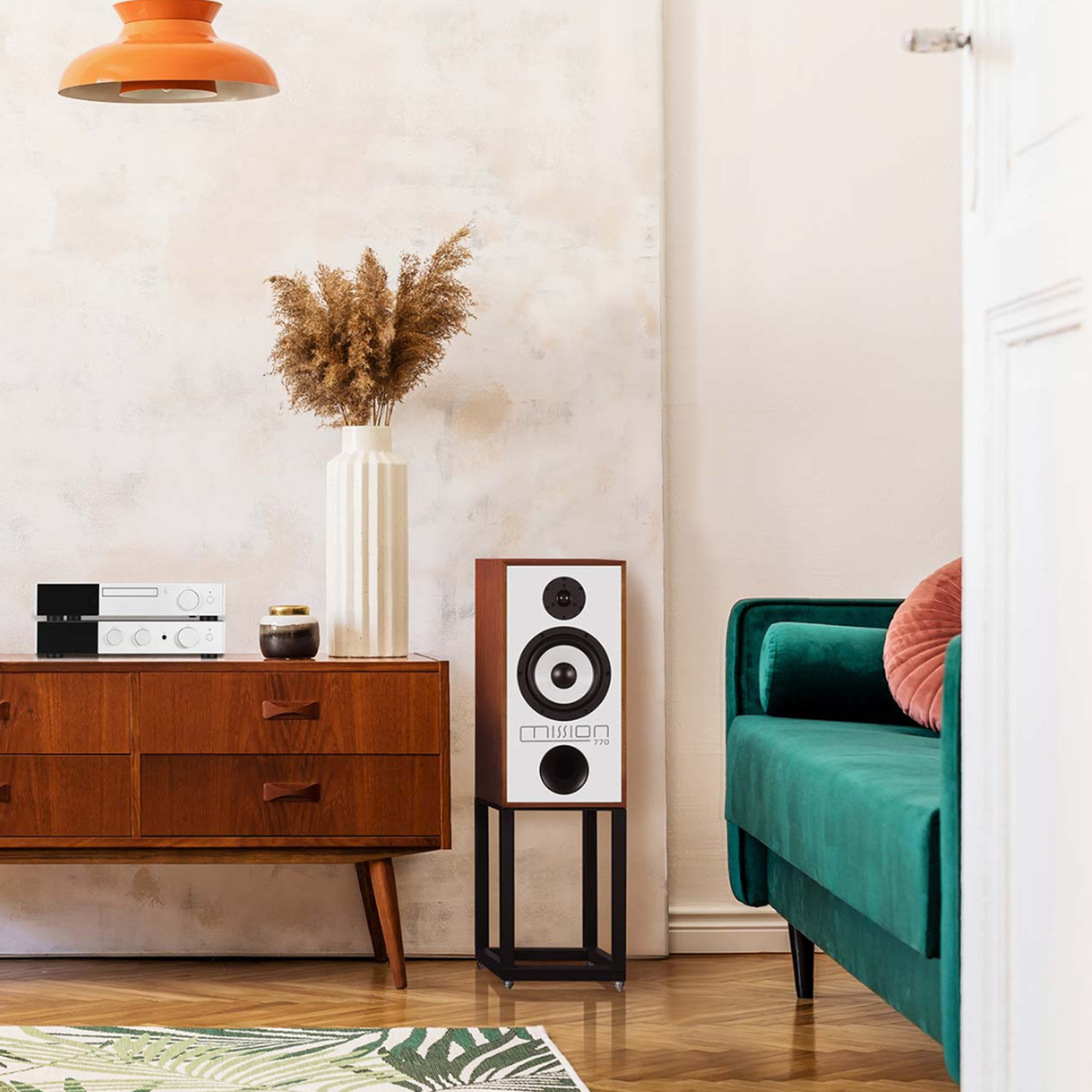 Mission speaker against wall next to green sofa and cabinet