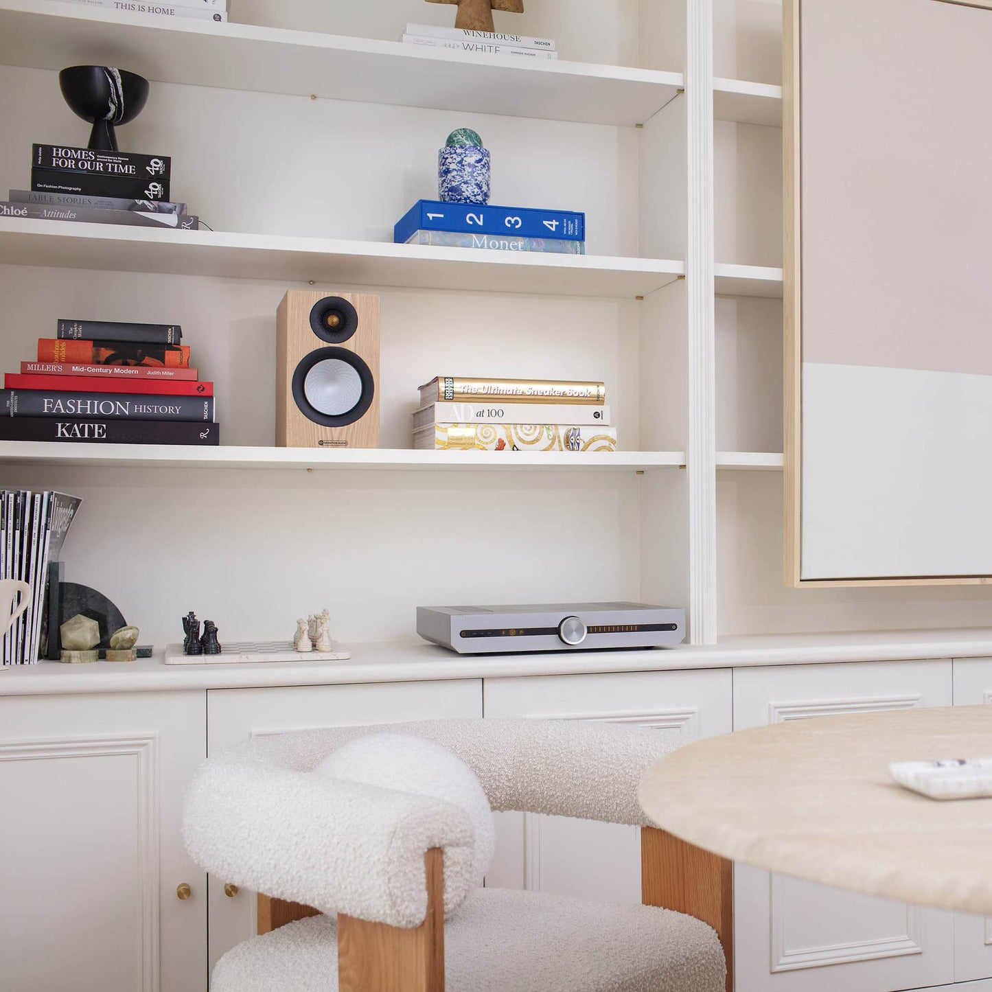 Modern home office with shelves, books, and decorative items.