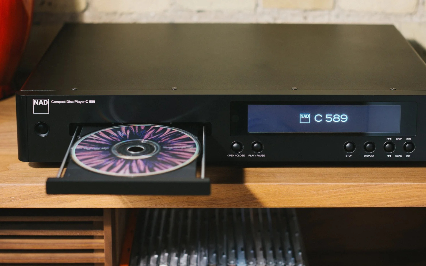 Black CD player with a CD in the tray on a wooden surface