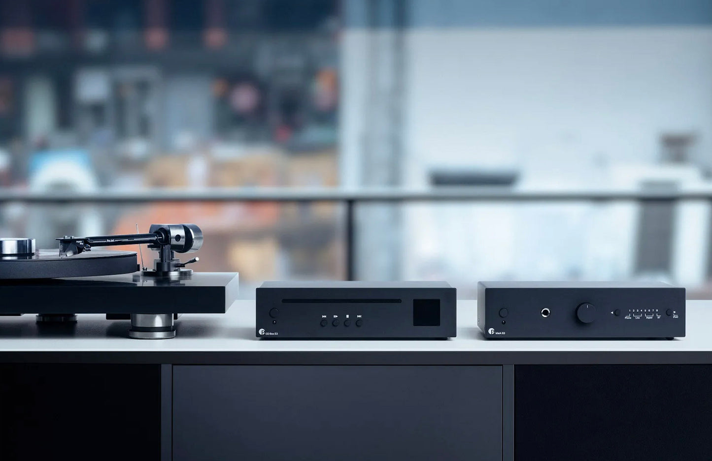 Audio equipment including a turntable and amplifiers on a blurred background