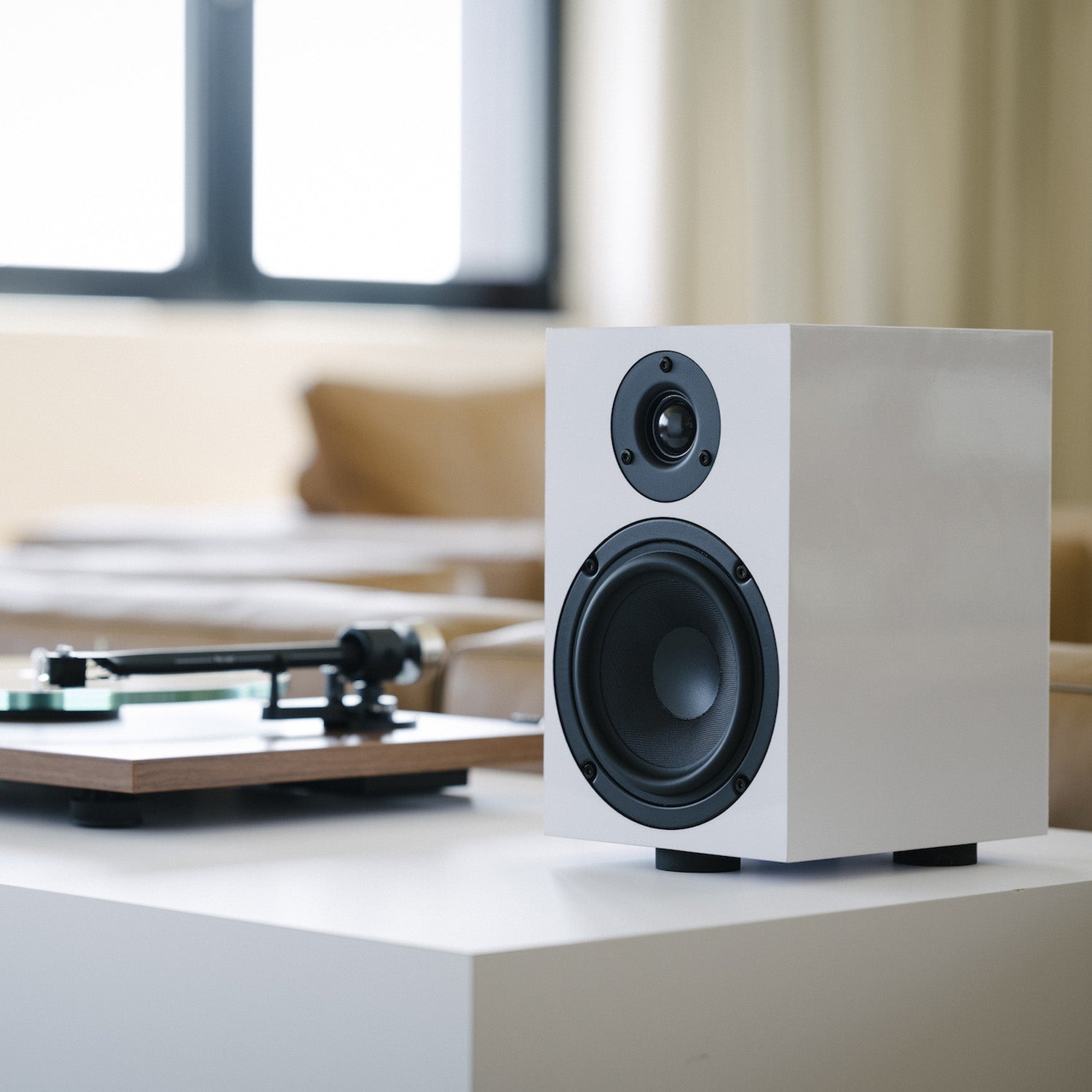 Pro-Ject Speaker Box 5 E Speakers white on table next to turntable