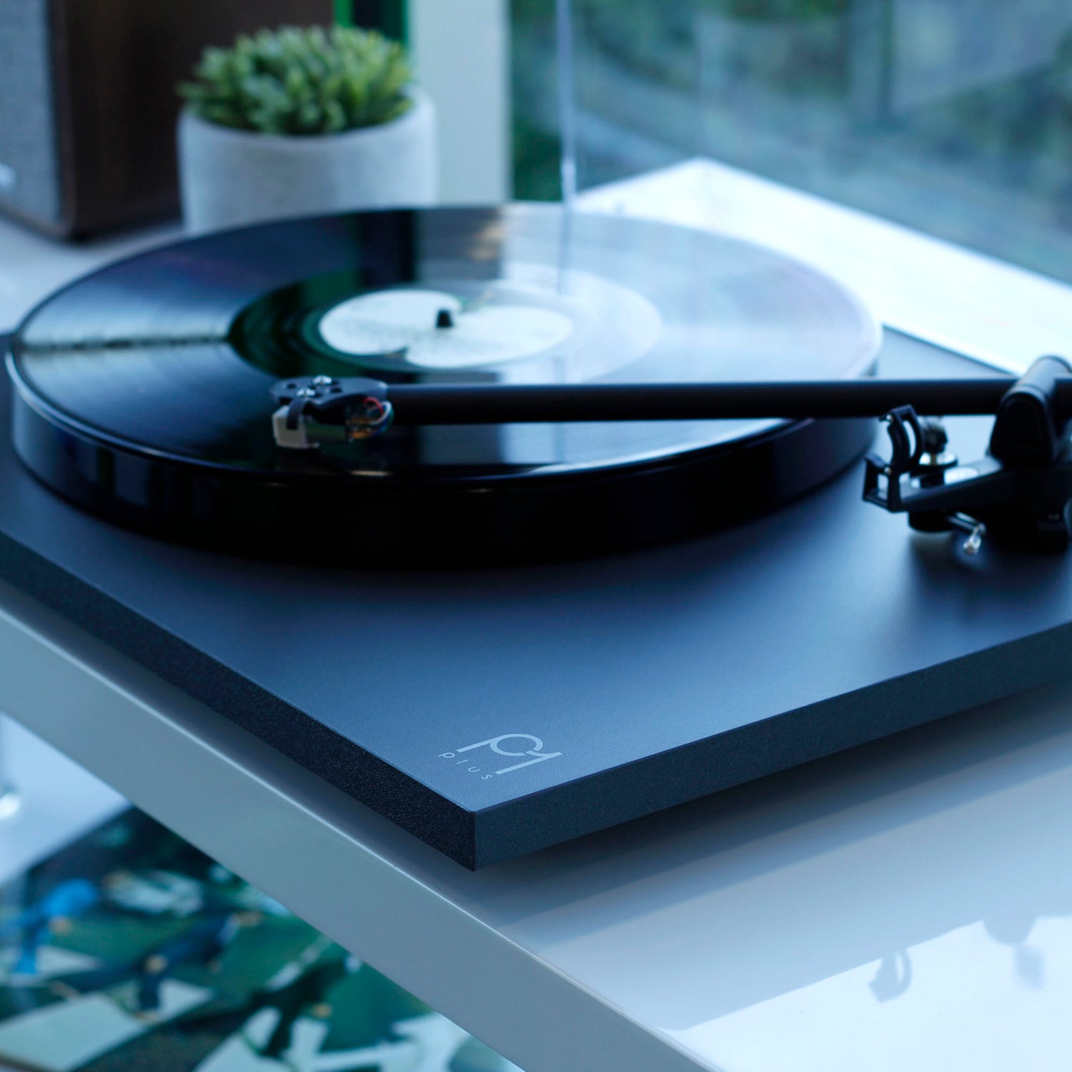 Rega Planar 1 Plus sitting on shelf in matte black
