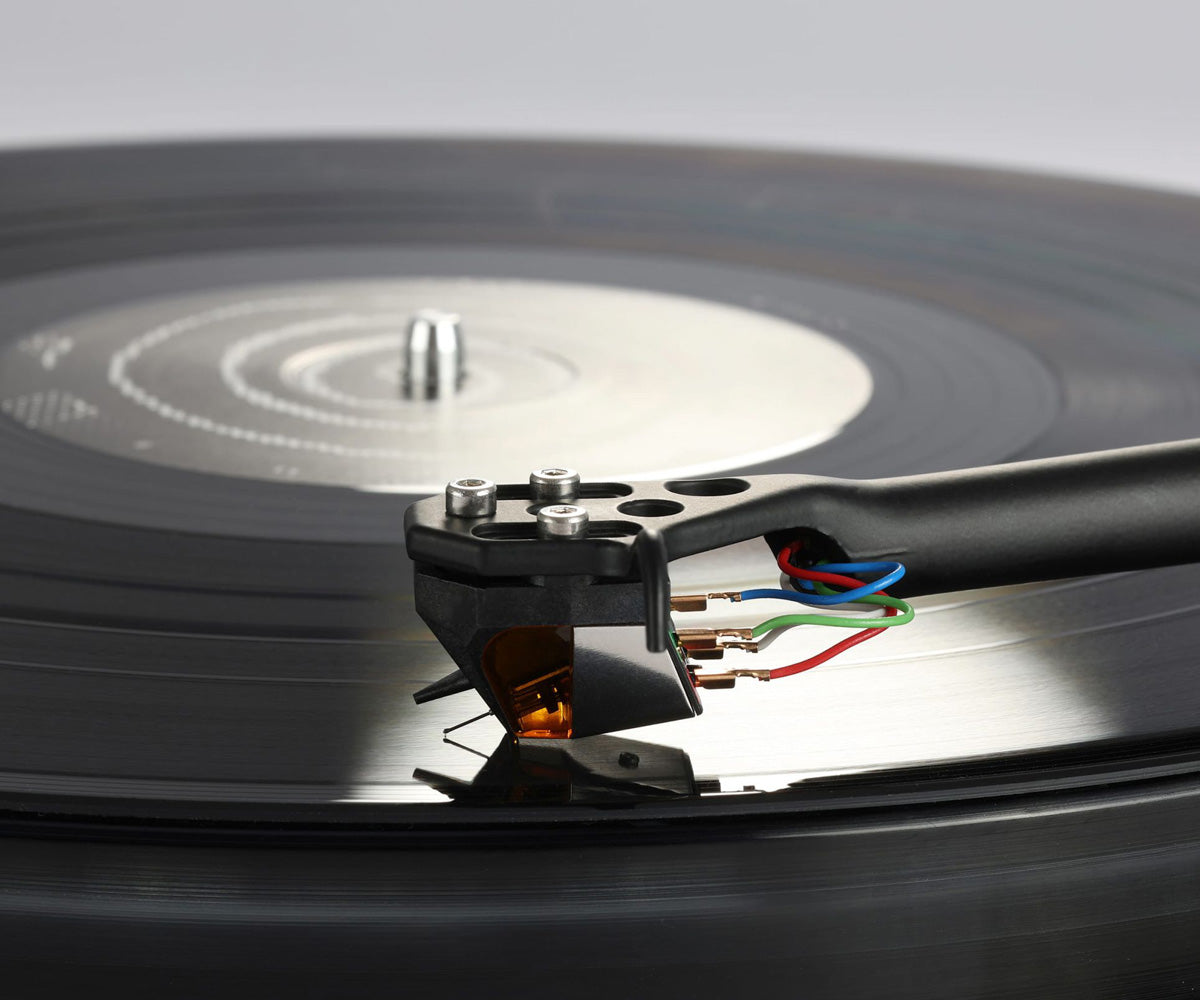 Close-up of a turntable needle on a vinyl record with a blurred background
