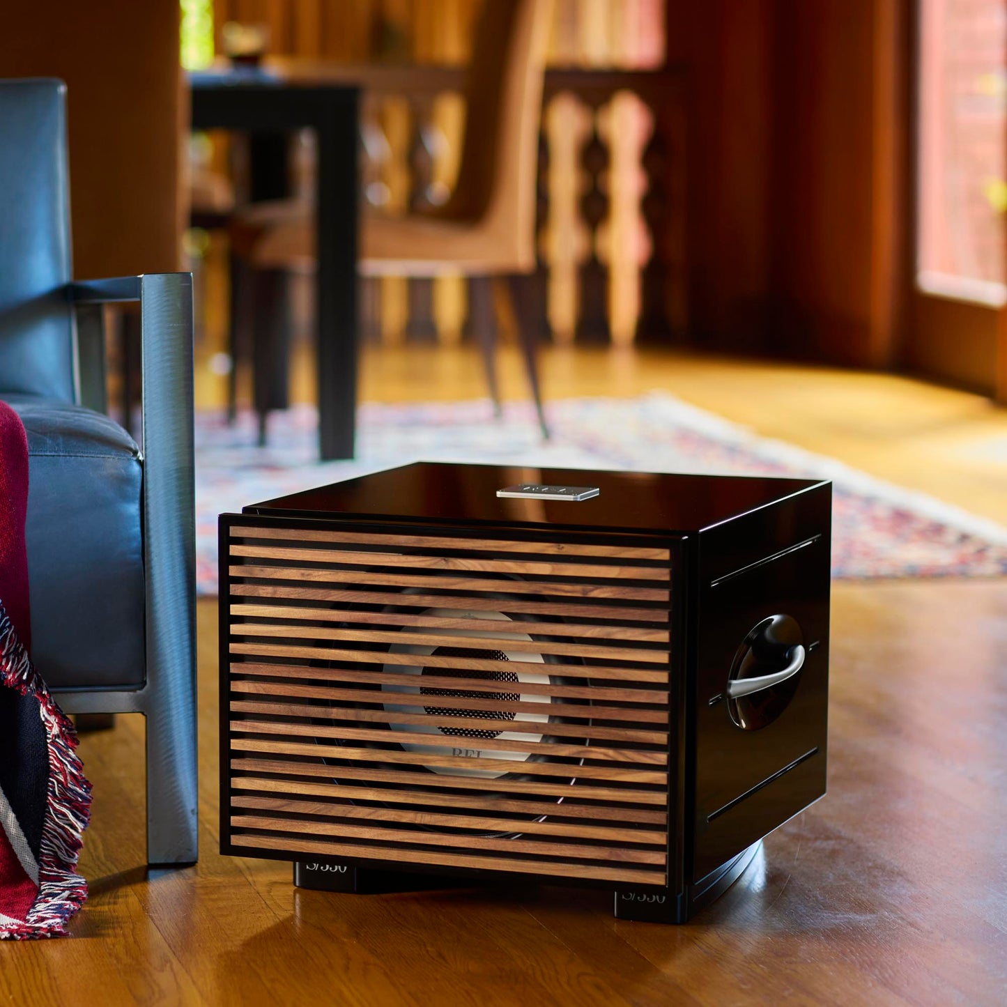 Black REL S/550 Subwoofer with wood grille in living room