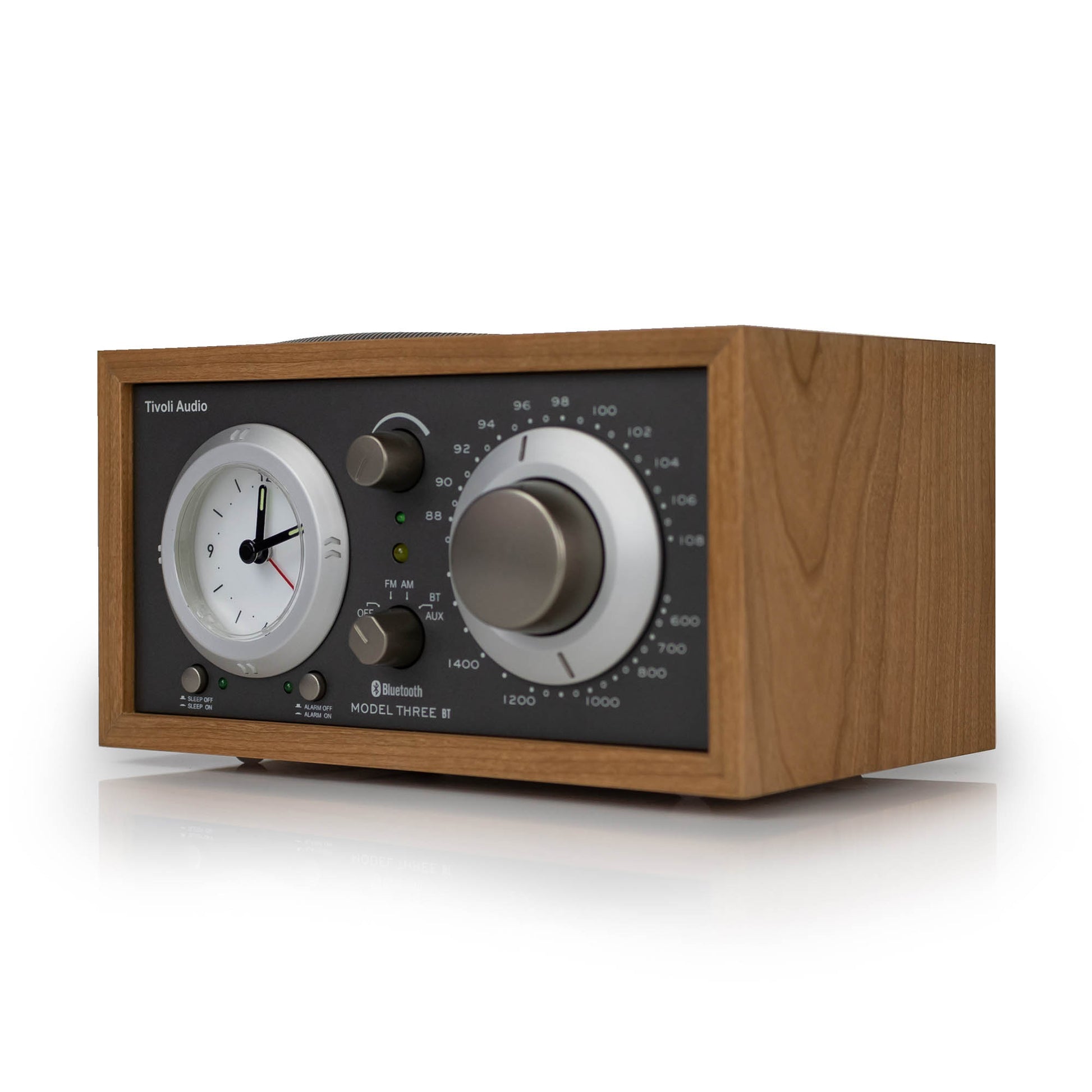 Wooden clock radio with analog display and control knobs on a white background