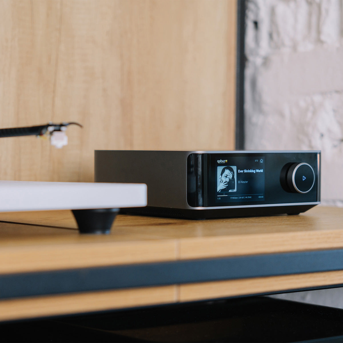 Modern audio device on a wooden shelf with a blurred background