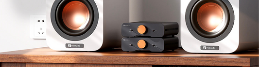 2 amplifiers sitting between 2 white speakers