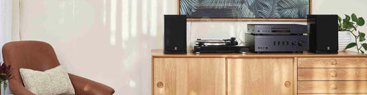 hifi system set up on oak cabinet and brown chair in corner