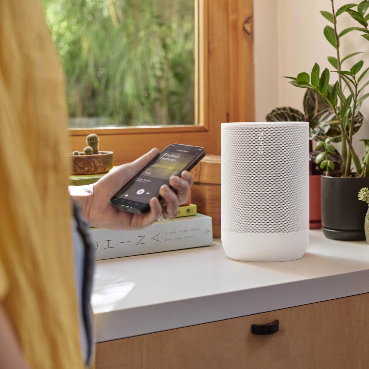 wireless speaker on bench with lady using app