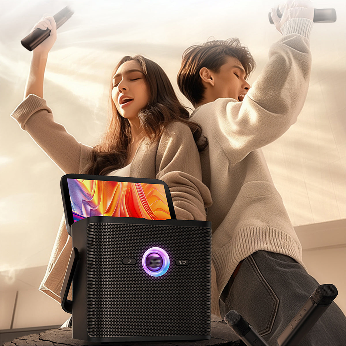 Two people enjoying music from a portable speaker with a colorful display.