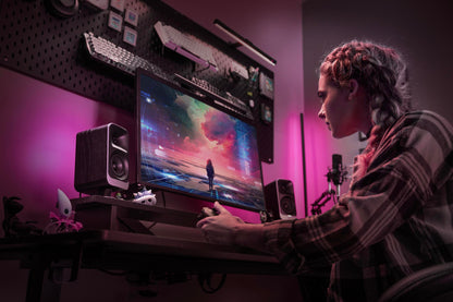 Person using a computer in a dark room with pink lighting