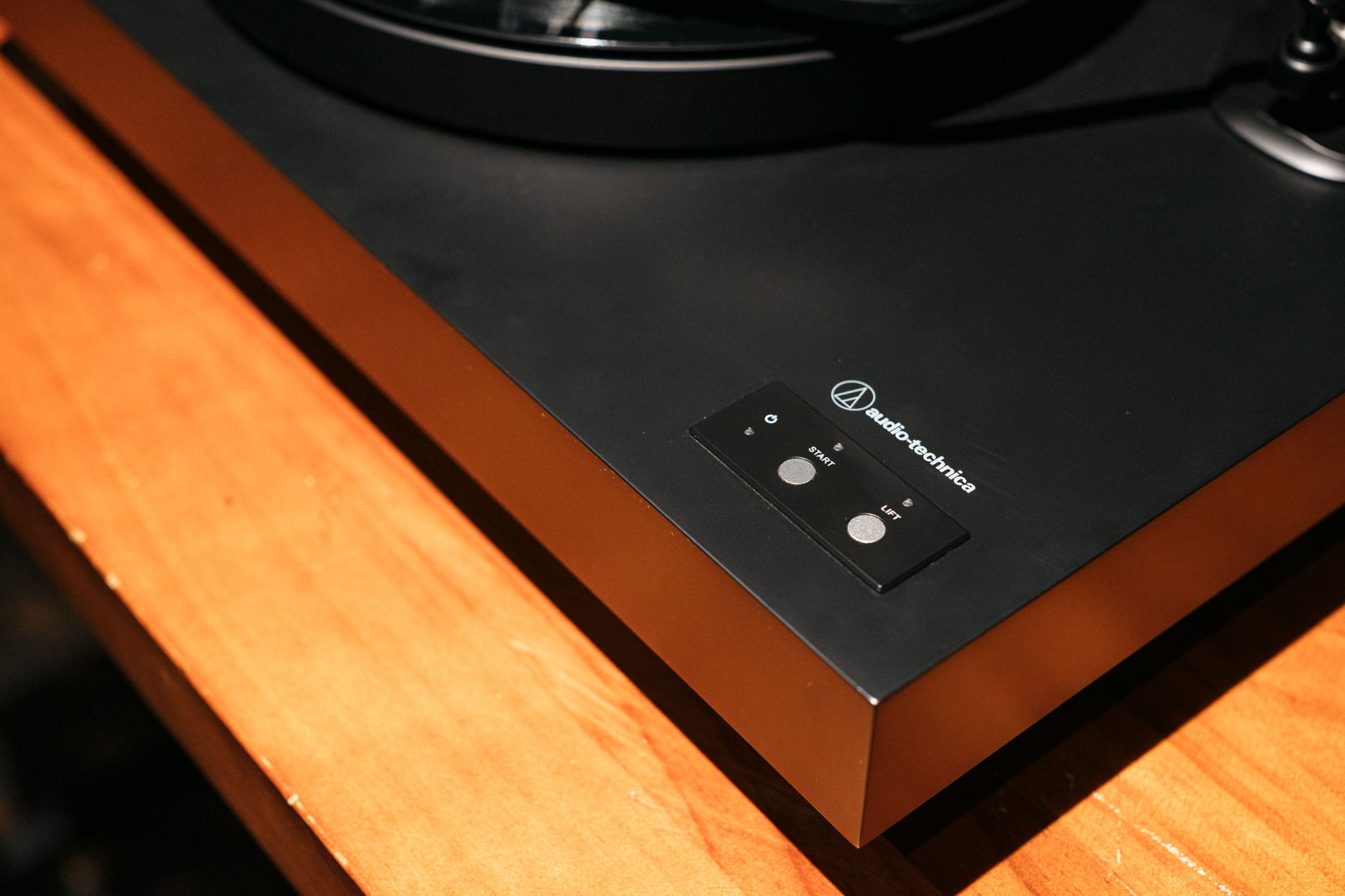 Turntable with a wooden plinth and black turntable surface