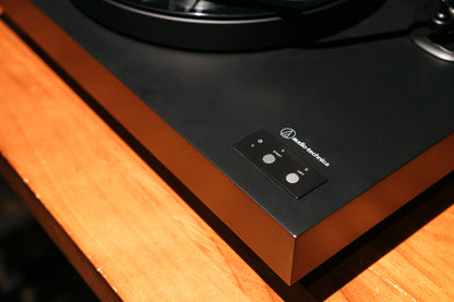 Turntable with a wooden plinth and black turntable surface