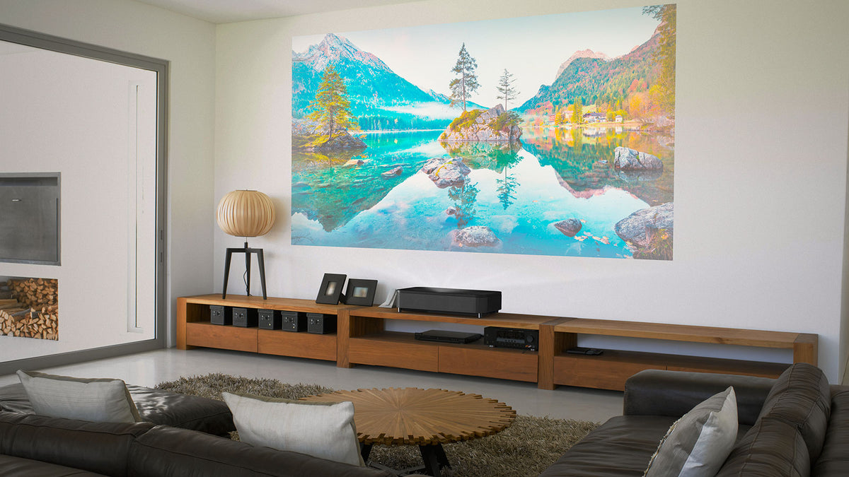 Living room with a projector and screen displaying a scenic landscape, surrounded by furniture and decor.