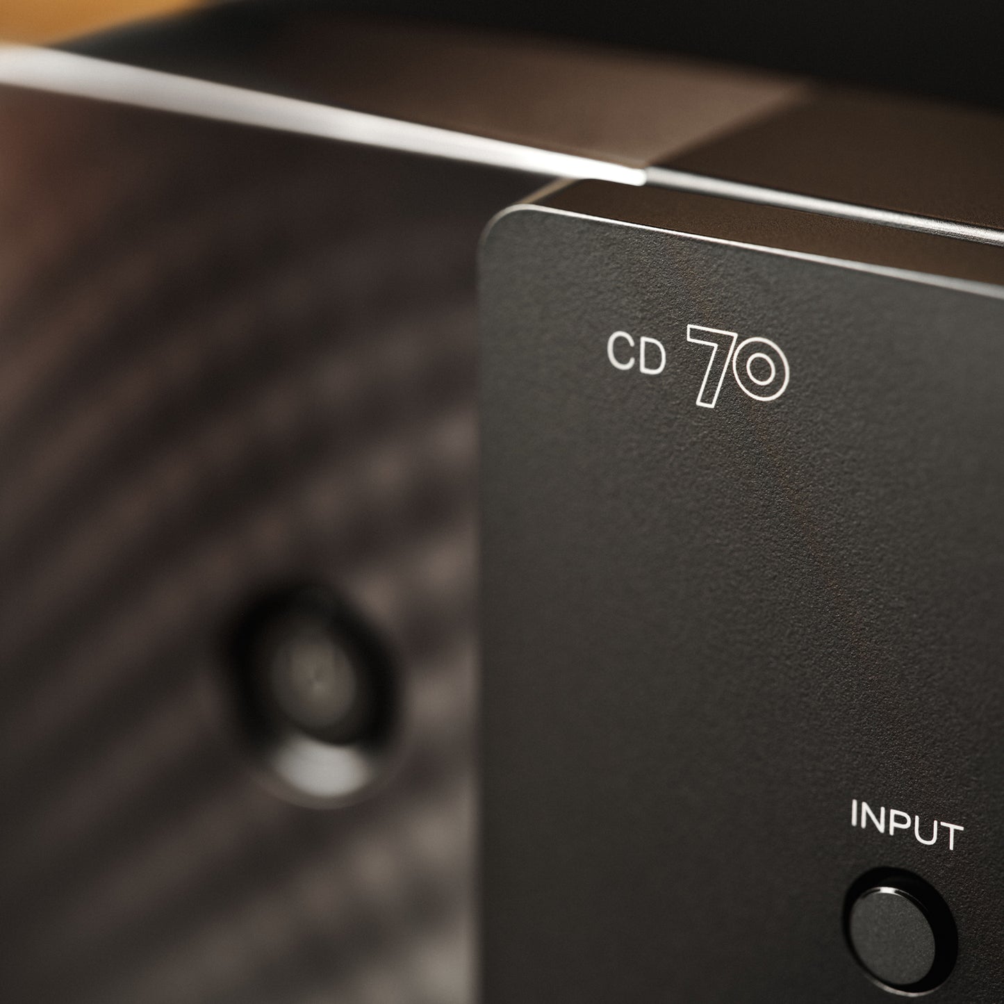 Close-up of a black electronic device panel with white text reading 'CD 70' and 'INPUT' next to a round button.