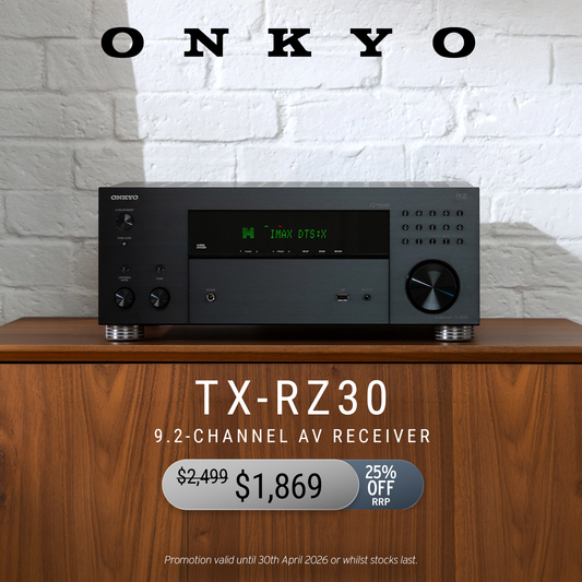 Onkyo TX-RZ30 9.2-channel AV receiver on a wooden surface with a white brick wall background.