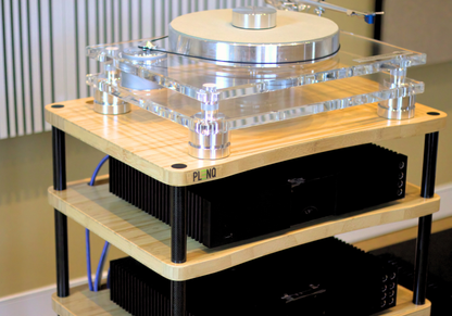 Turntable setup with clear plinth and wooden base on a blurred indoor background