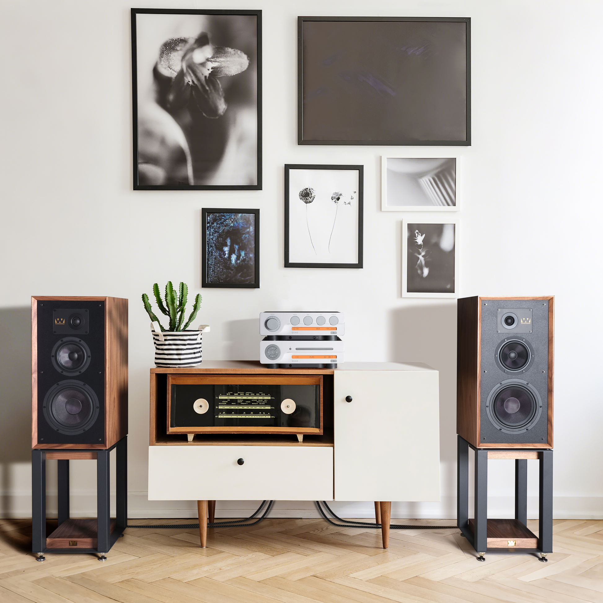 Modern interior with speakers, a cabinet, and framed pictures on the wall.