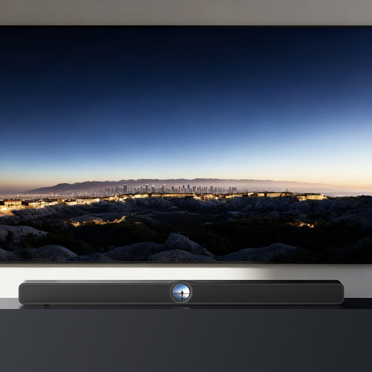 Soundbar below a television displaying a cityscape at dusk.