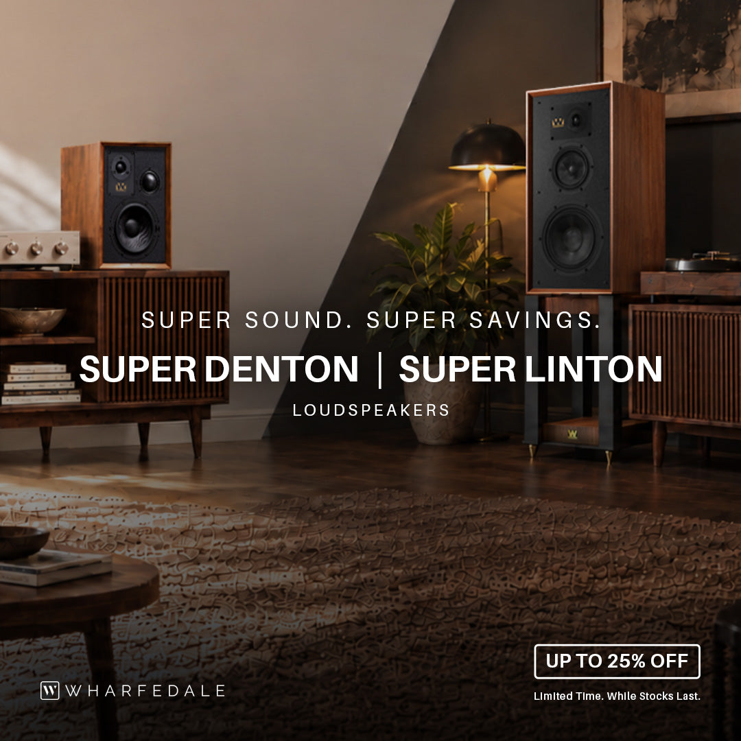 A lifestyle promotional image for Wharfedale loudspeakers, featuring two wooden tower speakers in a modern living room setting.