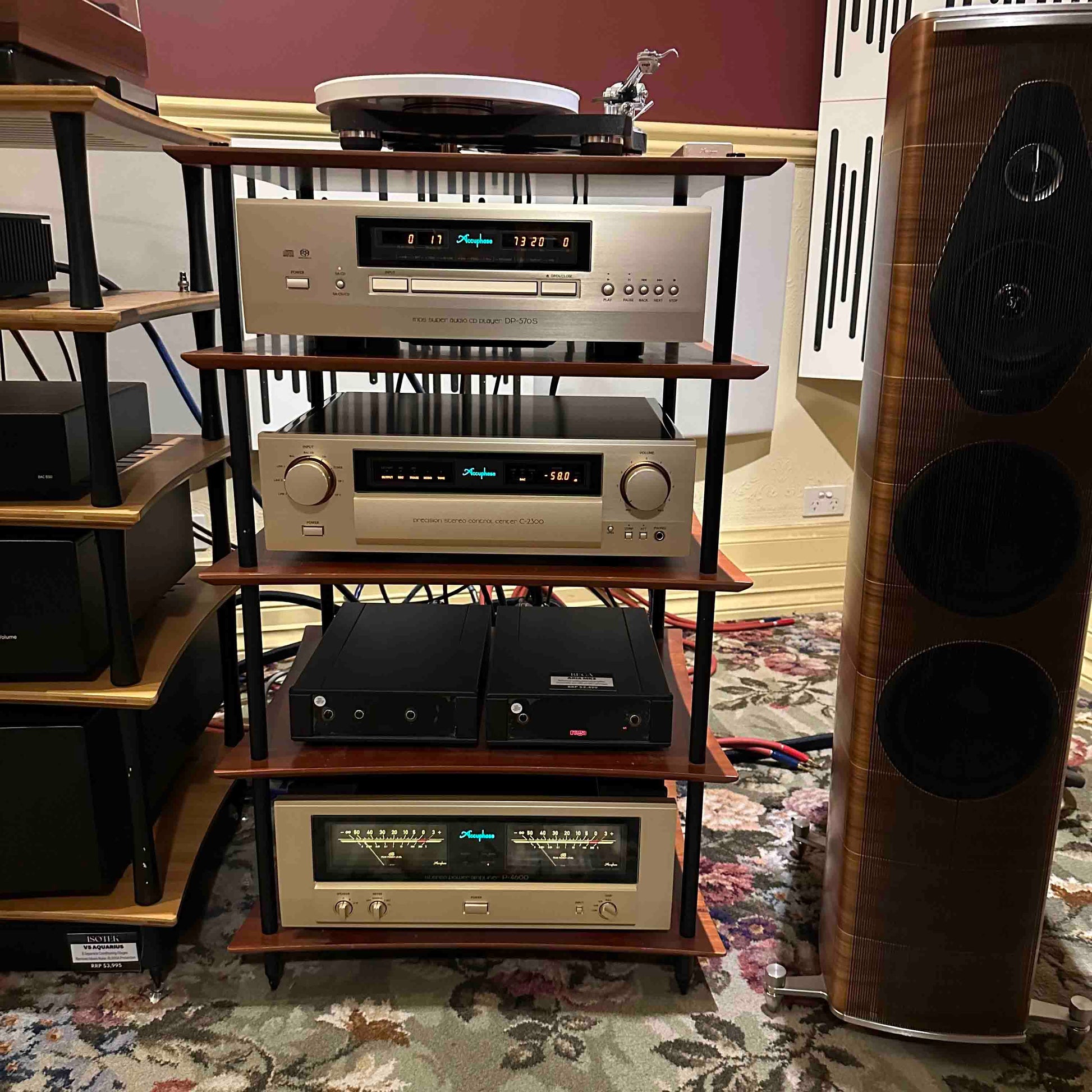 Audio equipment including amplifiers and speakers on a wooden shelf.