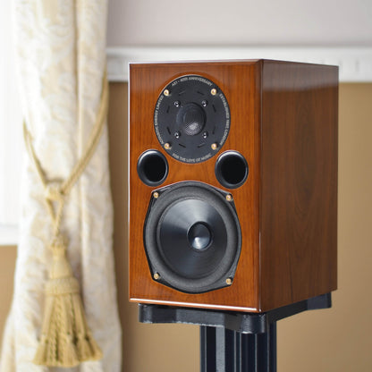 Walnut Acoustic Energy AE1 40th Anniversary Edition on a stand against a neutral background