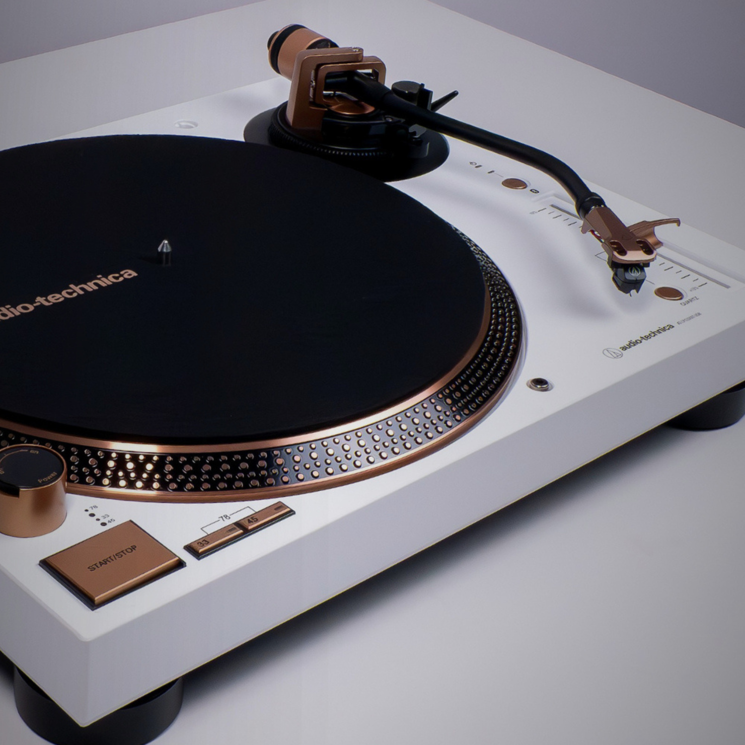 Audio-technica turntable with white base and bronze accents on a gray background