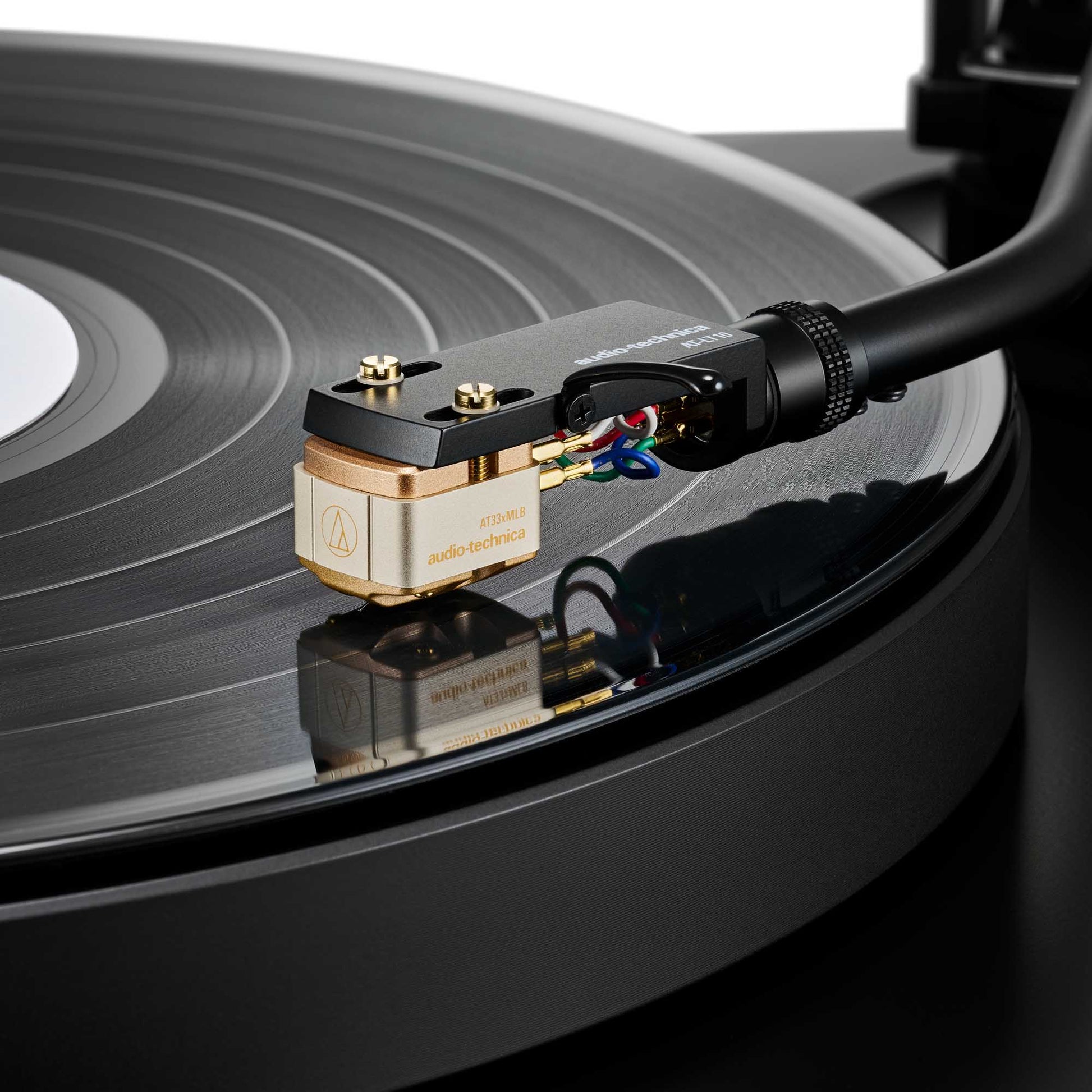 Close-up of a Audio Technica AT33xMLB Moving Coil Cartridge on a vinyl record