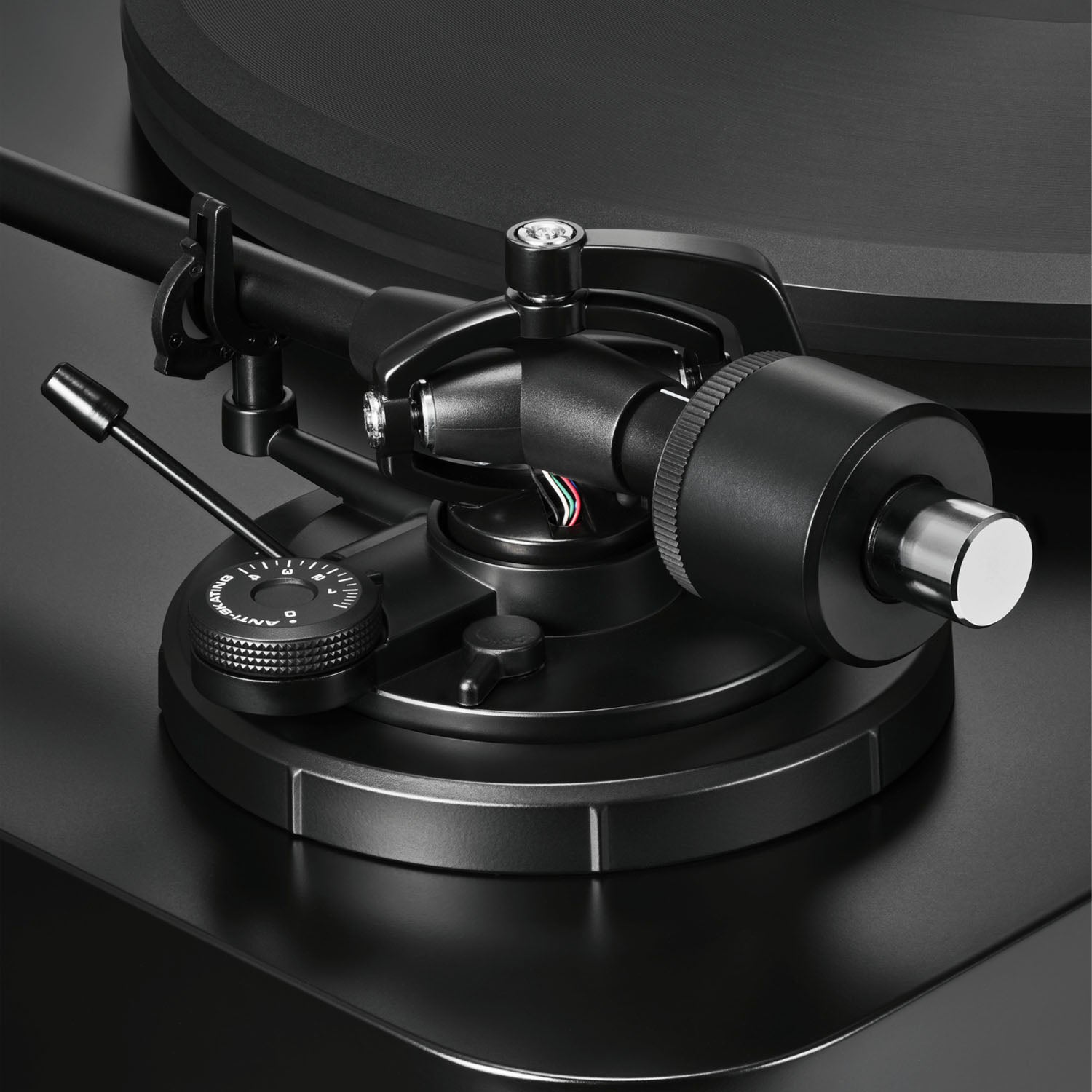 Close-up of a black turntable cartridge on a dark background