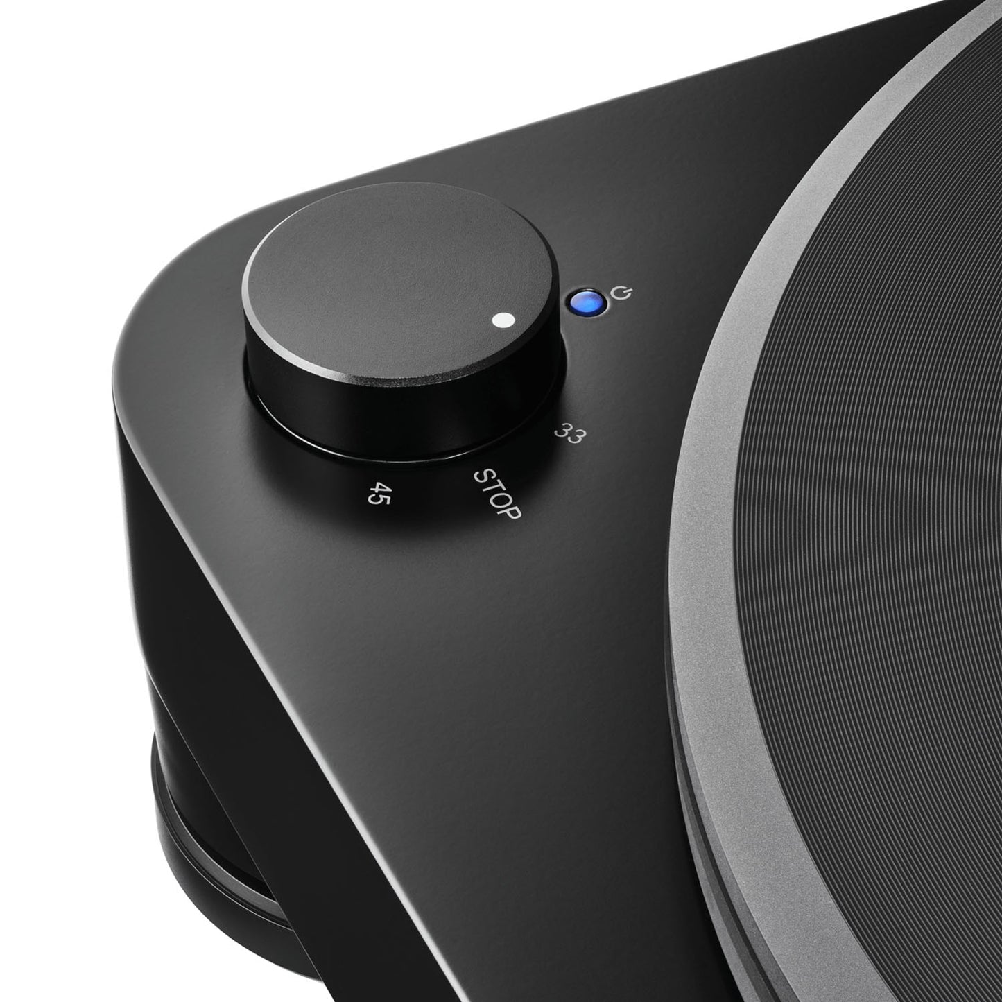 Close-up of a black turntable with a control knob and button on a white background
