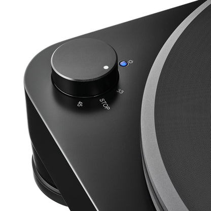 Close-up of a black turntable with a control knob and button on a white background