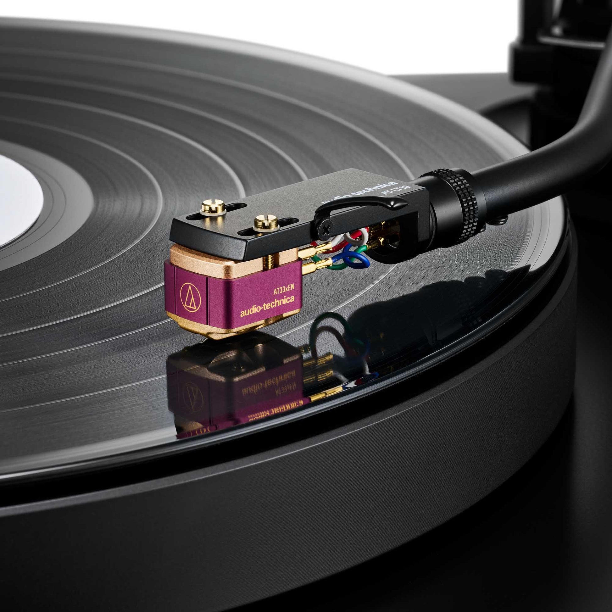 Close-up of a Audio Technica AT33xEN Dual Moving Coil Stereo Cartridge on a vinyl record