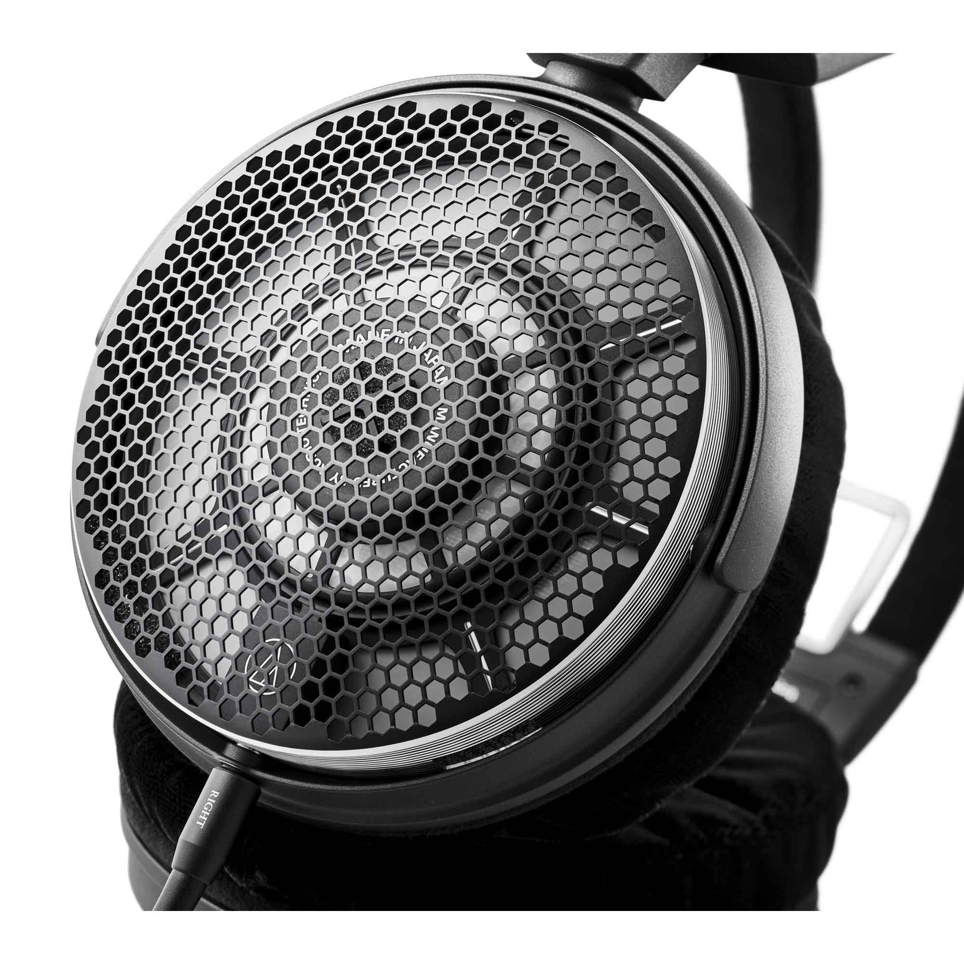 Close-up of a high-fidelity headphones driver unit with honeycomb pattern on a white background