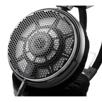 Close-up of a high-fidelity headphones driver unit with honeycomb pattern on a white background