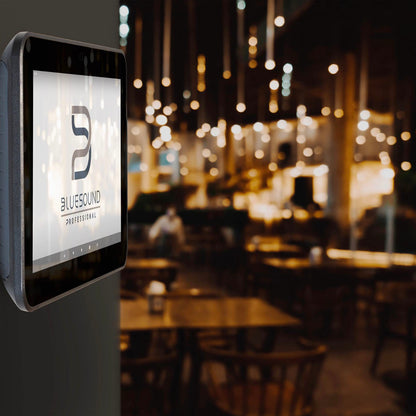 Touchscreen display with Bluesound logo in a restaurant setting