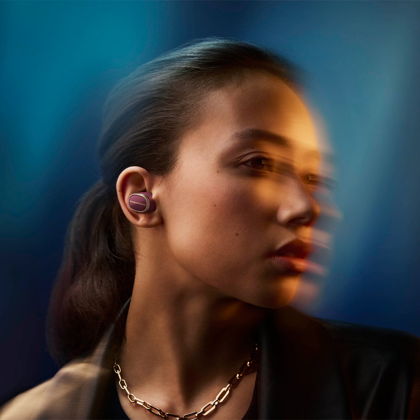 Woman wearing wireless earbuds with a blurred background